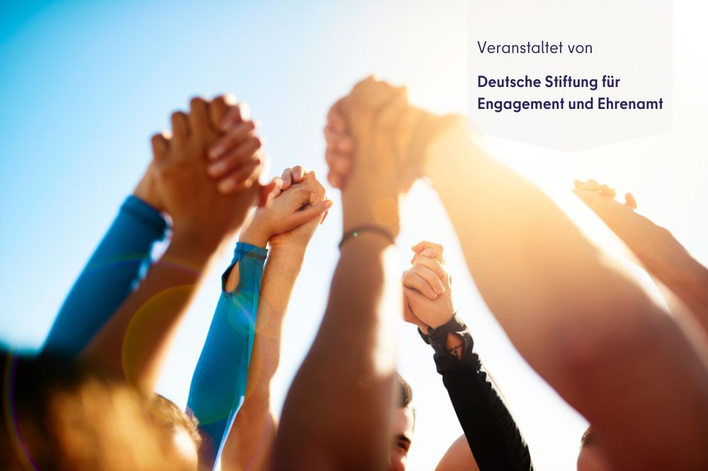 Mehrere Häned sind in die Luft gestreckt. Ein paar Hände sind ineinander gegriffen.