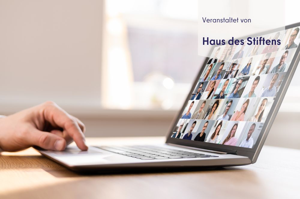 ein Laptop steht auf einem Tisch. Auf dem Desktop sieht man viele verschiedene Gesichter.